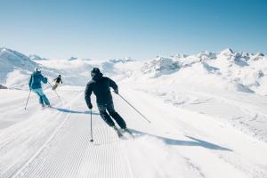 three people are skiing down a snow covered mountain at Naturhaus Loacker in Lech am Arlberg