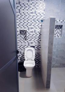 a bathroom with a white toilet in a stall at Amouage résidence 3 in Sidi Ifni