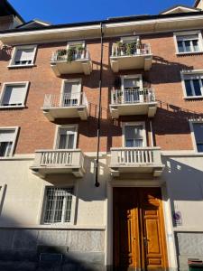 un edificio de ladrillo con 2 balcones y una puerta en Coli's House en Turín