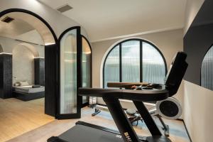 MS Collection Aveiro - Palacete Valdemouro في أفيرو: غرفة مع صالة ألعاب رياضية مع آلة ركض ونوافذ