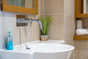 a bathroom with a sink and a faucet at Deluxe 2Bed Duplex Apartment & parking in London