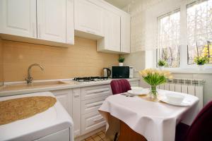 a kitchen with a table with a vase of flowers on it at Удобная двушка близ Атакента in Almaty