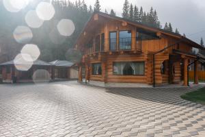 a large wooden house with a stone driveway at Chalet Ciocanesti in Ciocăneşti