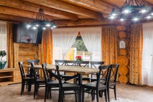a dining room with a wooden table and chairs at Chalet Ciocanesti in Ciocăneşti