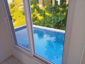 a window with a view of a swimming pool at Coral Views Village - uMaMi in French Harbour