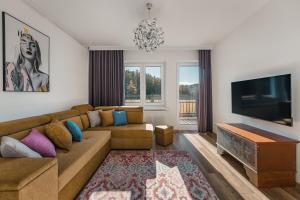 a living room with a couch and a flat screen tv at Willa Anna Maria in Szczawnica