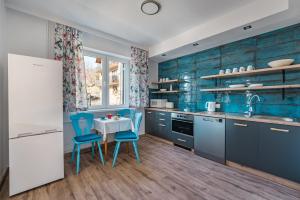 a kitchen with blue cabinets and a table and chairs at Willa Anna Maria in Szczawnica