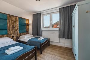 a hotel room with two beds and a window at Willa Anna Maria in Szczawnica