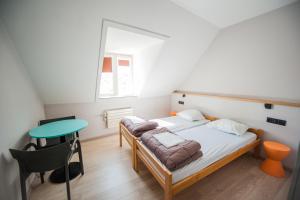 a small bedroom with a bed and a table at HI Brussels Jacques Brel Hostel in Brussels +42 photos