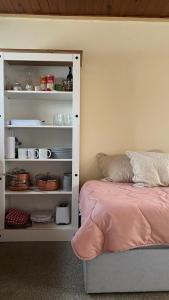 a bedroom with a bed and a shelf with dishes at Casita de Piedra 11 in Trinidad