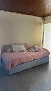 łóżko z różową kołdrą w pokoju w obiekcie Casita de Piedra 11 w mieście Trinidad