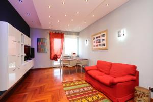 - un salon avec un canapé rouge et un bureau dans l'établissement Casa sotto le stelle, à Turin