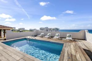 a swimming pool on the roof of a building with the ocean at Fine 3 BR Oceanview Penthouse in Prime Location - La Perla Sky in Cupecoy