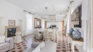 ein Wohnzimmer mit weißen Möbeln und einem Kamin in der Unterkunft Villa Urbis Taormina, luxury villa in the heart of Taormina with swimming pool & lift in Taormina