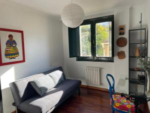 a living room with a couch and a window at Piso BOLBORETEIRO in Allariz