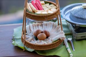 a table with two baskets with eggs in it at Oasis Phamee in Ban Pha Mi