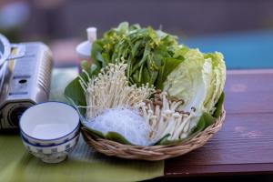Ban Pha Mi的住宿－Oasis Phamee，坐在桌子上的一篮生菜带镜子