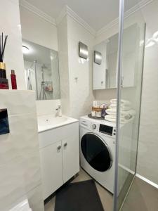 bagno bianco con lavatrice e lavandino di Studio 118 - A luxury place,10min walk to City Center a Timişoara