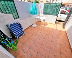 a patio with a blue umbrella and a chair at Sunflower Playa Lisa in Santa Pola
