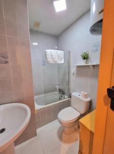 a bathroom with a toilet and a tub and a sink at Sunflower Playa Lisa in Santa Pola