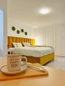 a bedroom with a bed with a cup on a table at Studio 118 - A luxury place,Self Check-in ,10 min from City Center in Timişoara