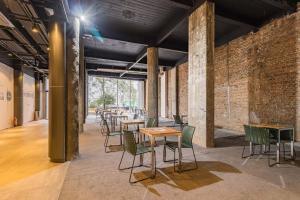 a row of tables and chairs in a room with brick walls at Town.Co Housi by My Way in Porto Alegre
