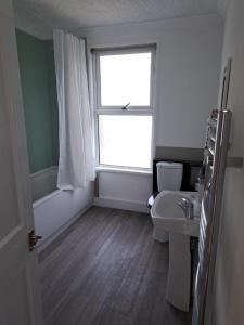 a bathroom with a window and a toilet and a sink at Luxury Double Room near London Seven Kings Train Station in Seven Kings