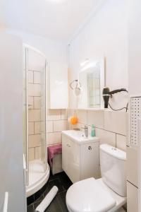 Baño blanco con aseo y lavamanos en Cosy 1 Bedroom in the heart of Montparnasse, en París