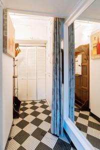 Habitación con suelo a cuadros y puerta corredera en Cosy 1 Bedroom in the heart of Montparnasse, en París