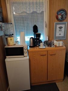 een keuken met een magnetron en een koelkast bij Gästezimmer Boxenstopp in Veitsbronn