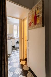 una cocina con una puerta que da a una cocina con suelo en Cosy 1 Bedroom in the heart of Montparnasse, en París