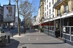 una calle de la ciudad con edificios y una acera con una calle en Cosy 1 Bedroom in the heart of Montparnasse, en París
