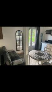 a living room with a table and a chair at Studio « Bâbord » Le Tréport - vue mer & falaises in Le Tréport
