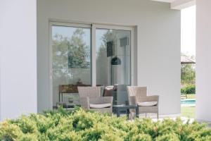 un patio con sedie e un tavolo su una casa di Helios a modern large villa with private pool set in a quiet location a Stavros