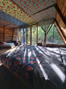 Santa María Huatulco的住宿－Planta Glamp Farm，一张大床,位于带大窗户的房间里