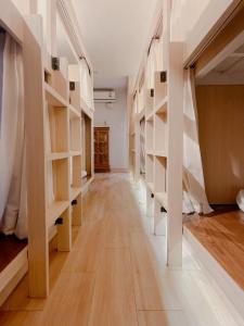 a hallway with white shelves in a room at Nama Hostel Chiangmai in Chiang Mai