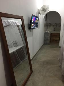 a mirror and a television in a room at Tropical Villa in Galle