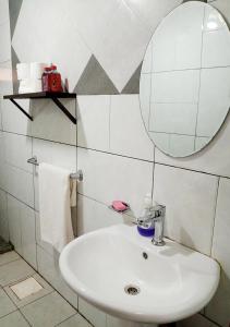 a bathroom with a sink and a mirror at La Couronne Suites in Bangui