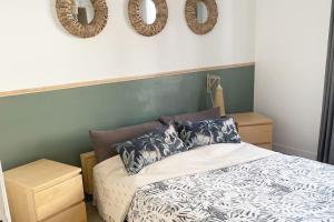 a bedroom with a bed and two wreaths on the wall at Calme - Balcon - 2 à 4 pers - WIFI - plage à 100m in Berck-sur-Mer