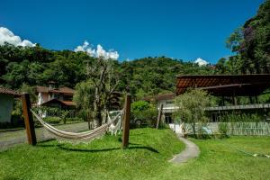 a hammock in a yard in front of a building at Chalé Le Refuge in Teresópolis +20 photos