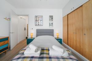 a bedroom with a large bed with towels on it at Ickburgh Road Guesthouse in London