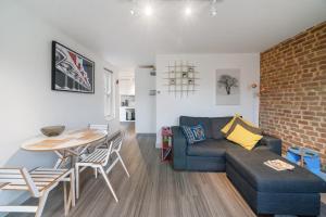 uma sala de estar com um sofá e uma mesa em Ickburgh Road Guesthouse em Londres