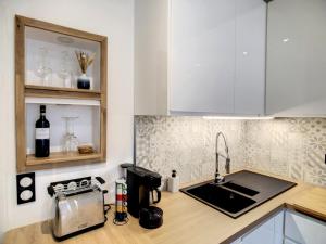 a kitchen with a sink and a counter top at Escalier 16 - 30 m plage du Sillon - Proche Intra in Saint Malo