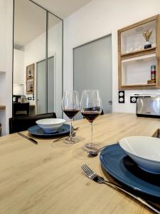 una mesa de madera con dos copas de vino. en Escalier 16 - 30 m plage du Sillon - Proche Intra, en Saint-Malo