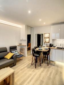 a kitchen and a living room with a table and chairs at Escalier 16 - 30 m plage du Sillon - Proche Intra in Saint Malo