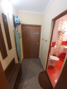 ein Bad mit einer Tür und einem WC in einem Zimmer in der Unterkunft Guest House Skalite in Sozopol