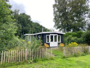 een klein huis midden in een tuin bij Natuurhuisje Veluwe met houtkachel en pizzaoven in Ermelo