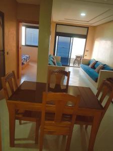 a dining room and living room with a table and chairs at Amouage résidence 4 in Sidi Ifni +11 photos