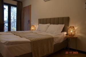 a bedroom with a large bed with two lamps at Arte Gdańsk in Gdańsk