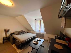 a bedroom with a bed and a table in it at Appartement Centre-ville / 6 prsn / Bord du doubs / Au pied de la citadelle in Besançon
